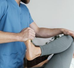 osteopathic-doctor-checking-female-patient-s-leg-movement
